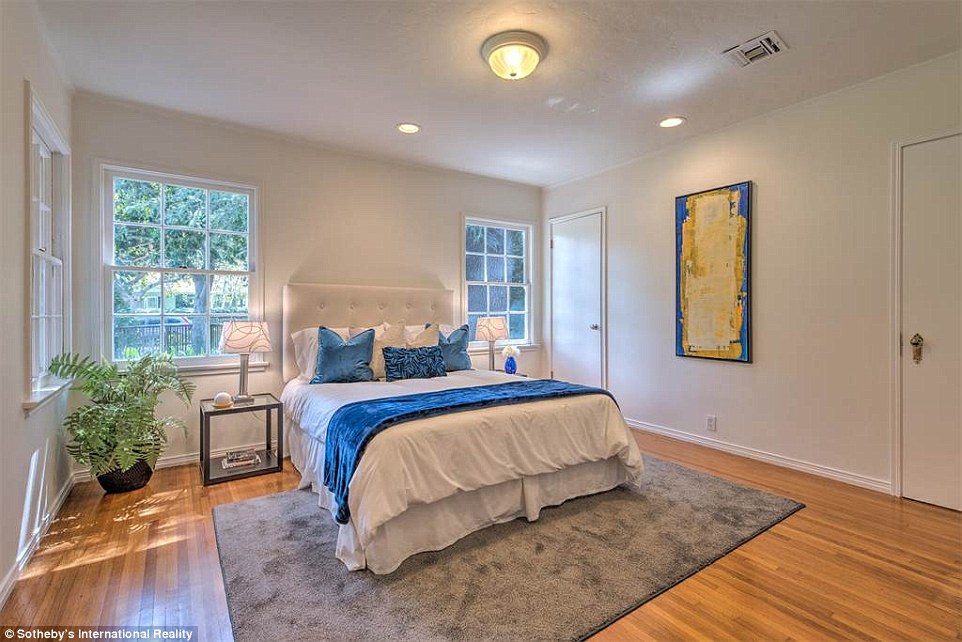 Welcome home: Another of the home's bedrooms features three large windows and beautiful wooden floors