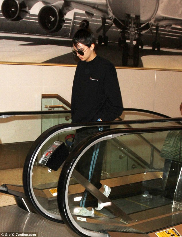 To the top: Kendall gets off an escalator with her bag in hand, seemingly deep in thought