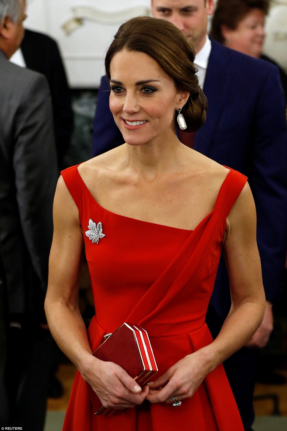 Shining example: Kate accessorised with a stunning broach paying homage to the Canadian flag and a matching red clutch bag as she turned heads at the reception