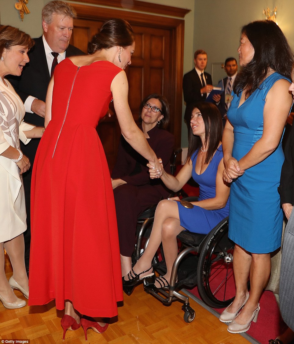 Royal hand shake: Kate, wearing her £1,000 Preen dress, shakes hands with an athlete at the glamorous reception