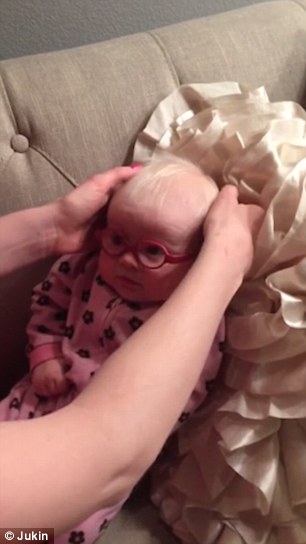Adorable footage filmed by the dad at home in America shows the diminutive pair of pink specs (complete with elastic head trap) being slipped over the baby's head... and her enchanting reaction.